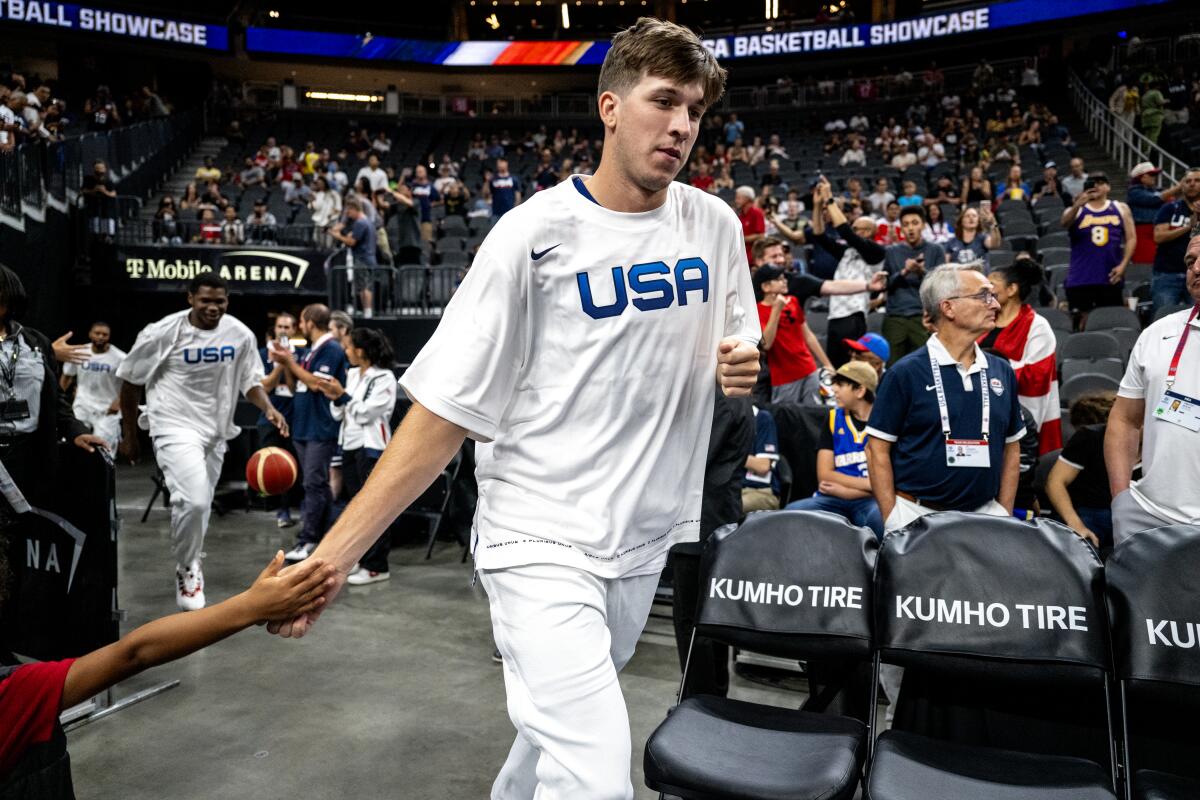 Austin Reaves slaps hands with a young fan before a FIBA World Cup exhibition game between the U.S. and Puerto Rico.