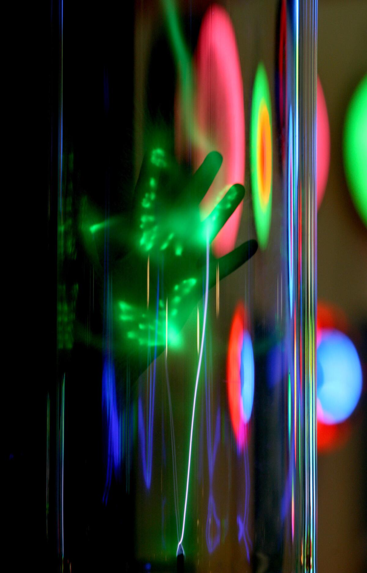 A hand touching Larry Albright's Green Plasma causes light effects at the Museum of Neon Art (MONA) across from the Americana at Brand on Brand Boulevard in Glendale on Wednesday, Dec. 2, 2015.