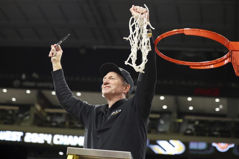 Long Beach State head coach Dan Monson participates in a net cutting ceremony.