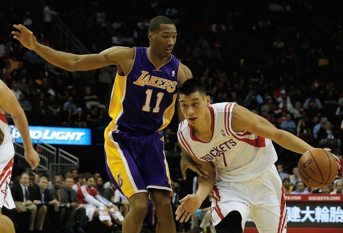 Rockets point guard Jeremy Lin (7) tries to dribble past Lakers guard Wesley Johnson during a game earlier this season in Houston.
