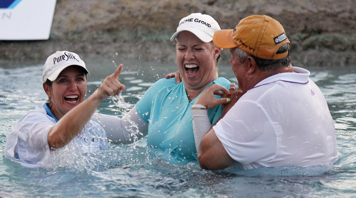 Brittany Lincicome, center, is joined by caddie Missy Pederson and father Tom Lincicome for the traditional leap into Poppy's Pond after winning the ANA Inspiration at Mission Hills Country Club.