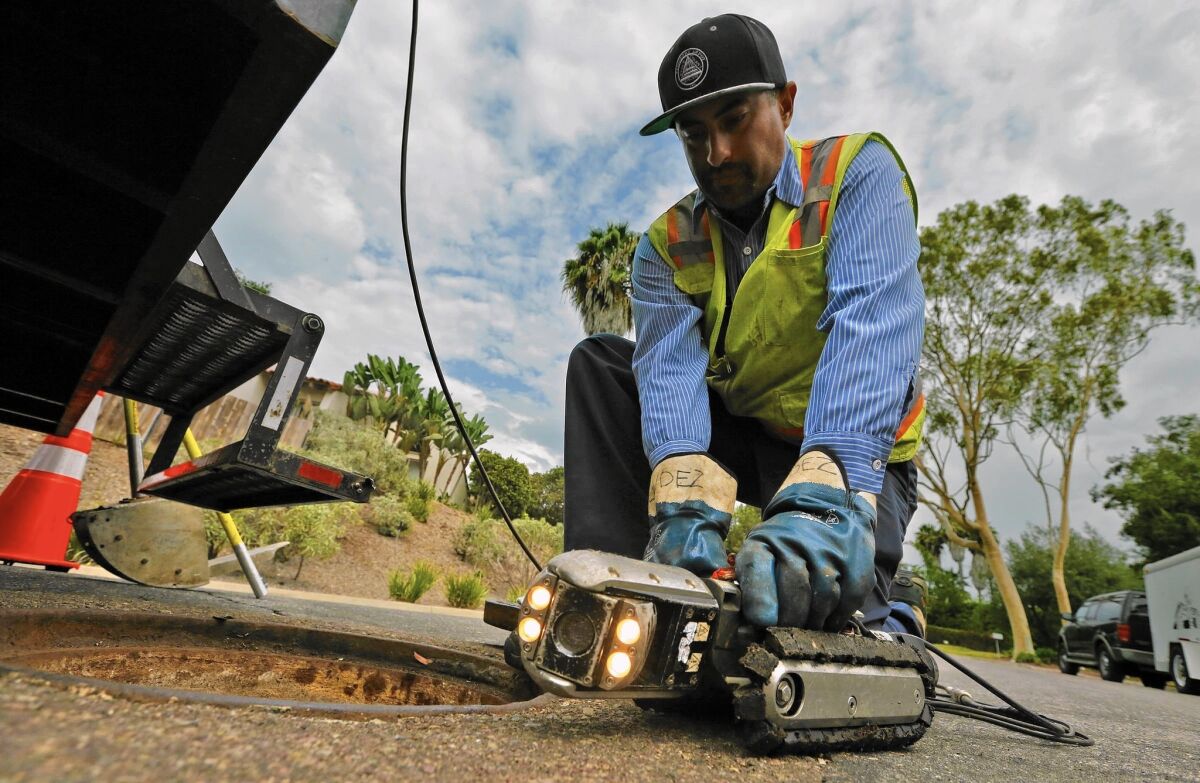 Hugo Gonzalez, a Leucadia Wastewater District technician, prepares a camera to search for roots in a Carlsbad, Calif., sewer line. Without normal levels of outdoor irrigation, tree roots in search of water have invaded sewer pipes and grown there over time.