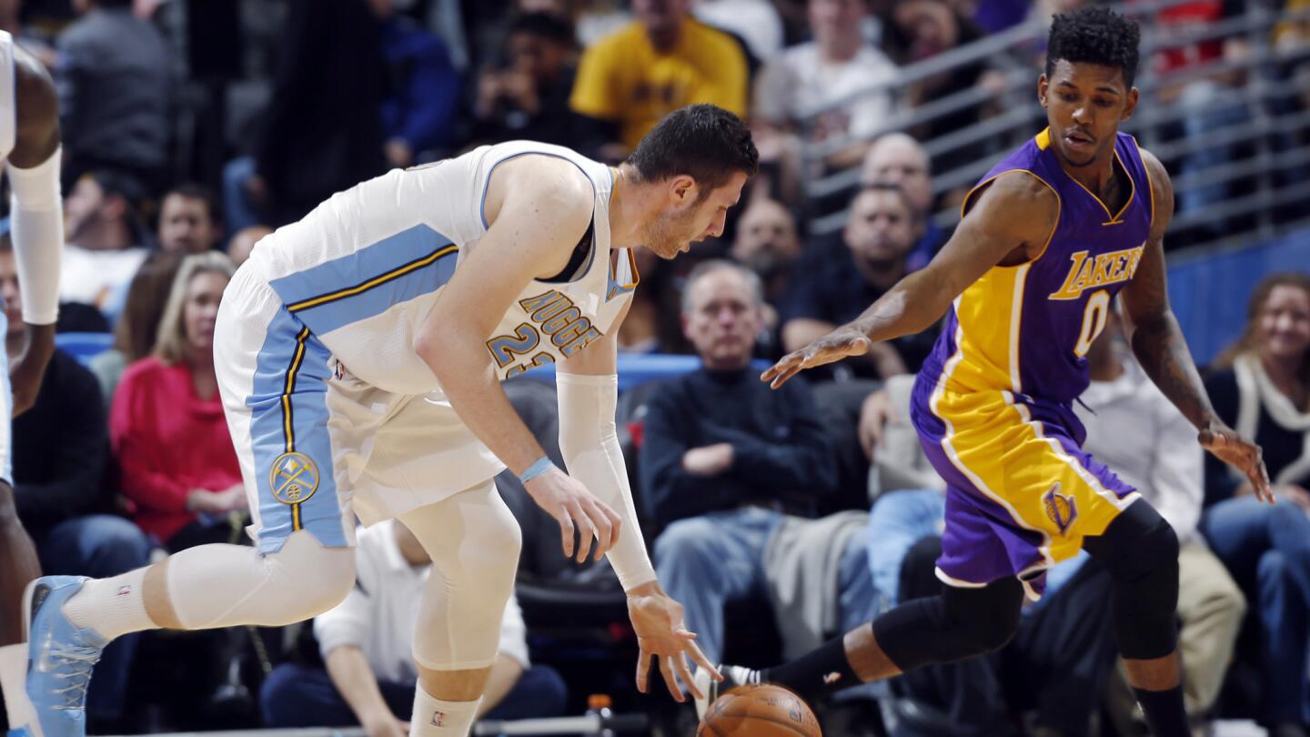 Denver Nuggets center Jusuf Nurkic, left, and Lakers small forward Nick Young chase after a loose ball during the Lakers' 111-103 road win on Dec. 30, 2014.