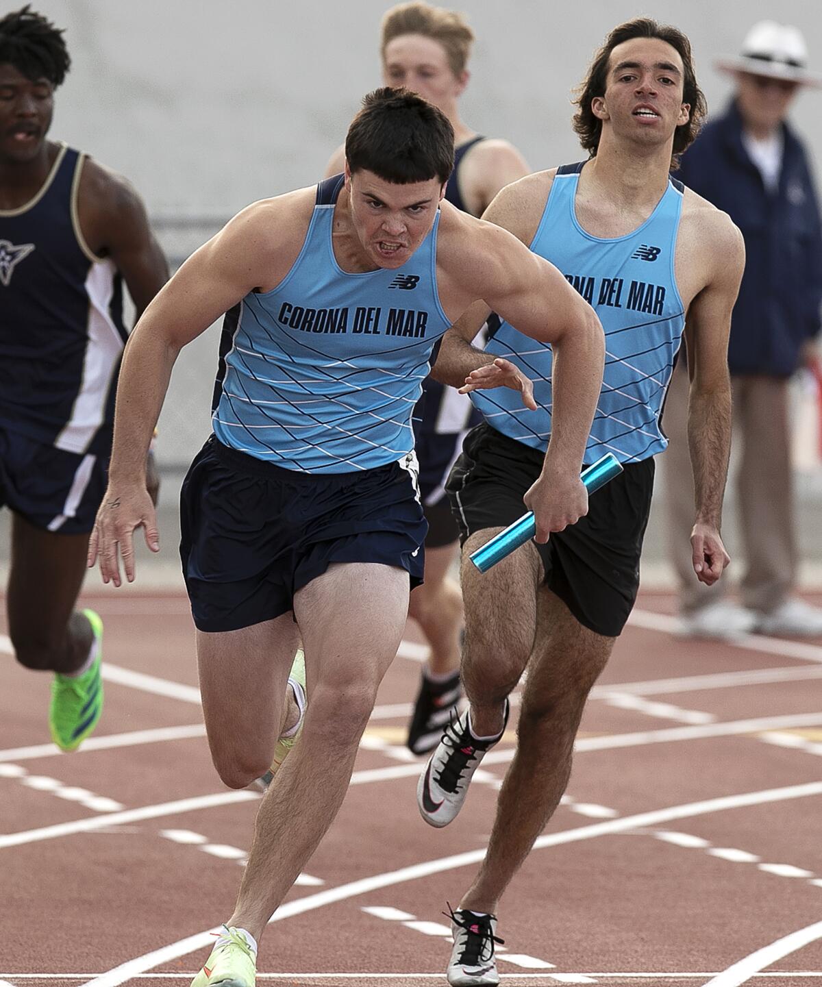 Corona del Mar's Jason Plumb, left, secures the hand-off from teammate Tanner Touchard, right, in the boys' 400-meter relay.