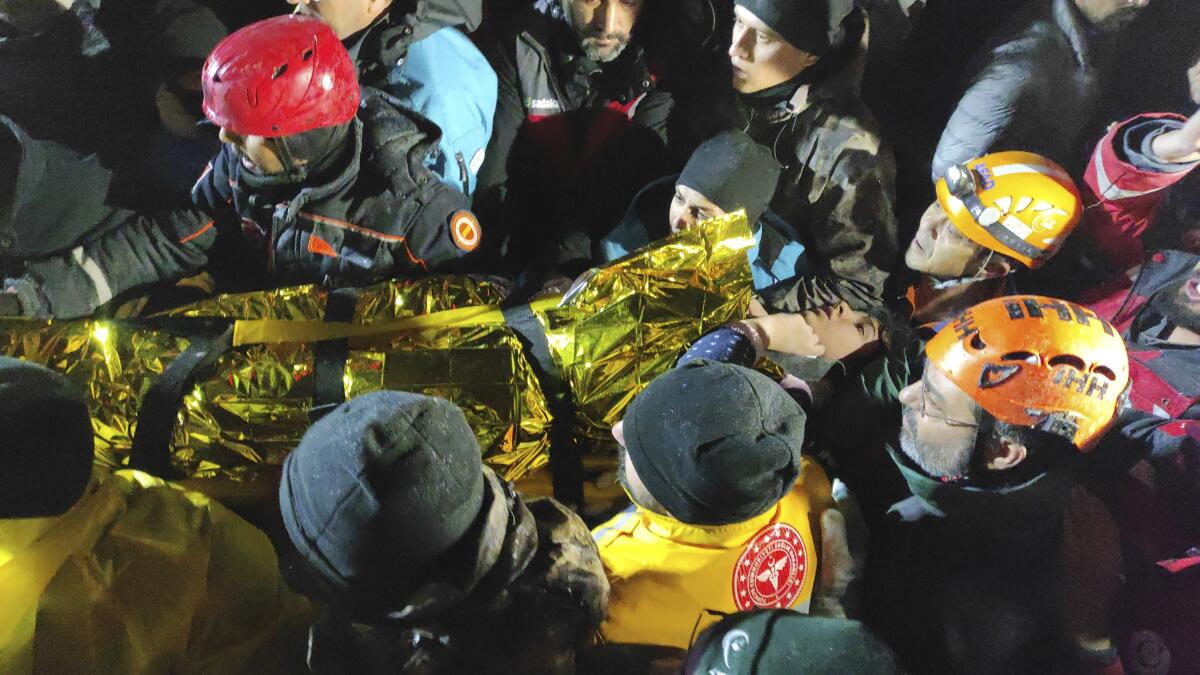 Rescue workers carry a young woman from a collapsed building