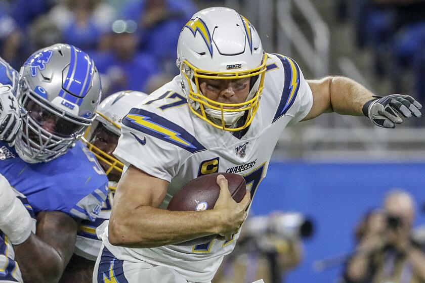 DETROIT, MICHIGAN, SUNDAY, SEPTEMBER 15, 2019 - Chargers quarterback Philip Rivers scrambles away from Lions linebacker Christian Jones during a third quarter drive at Ford Field. (Robert Gauthier/Los Angeles Times)