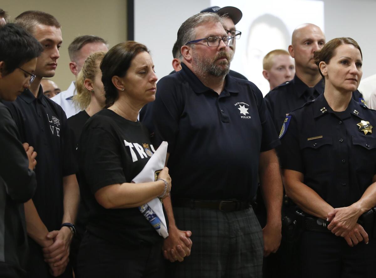Kelley and Denis O'Sullivan, the parents of slain Sacramento Police Officer Tara O'Sullivan, hold hands during a news conference in Sacramento on Tuesday.