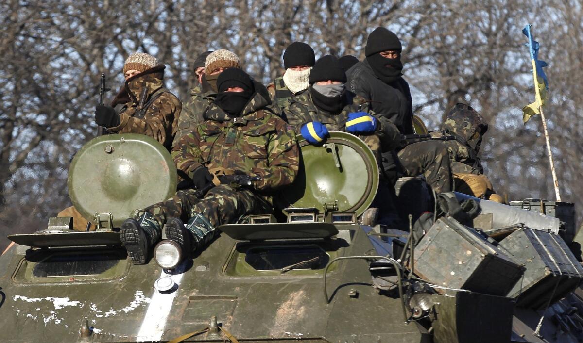 Ukrainian government soldiers sit on top of their armored vehicle driving toward the city of Debaltseve on Feb. 17.