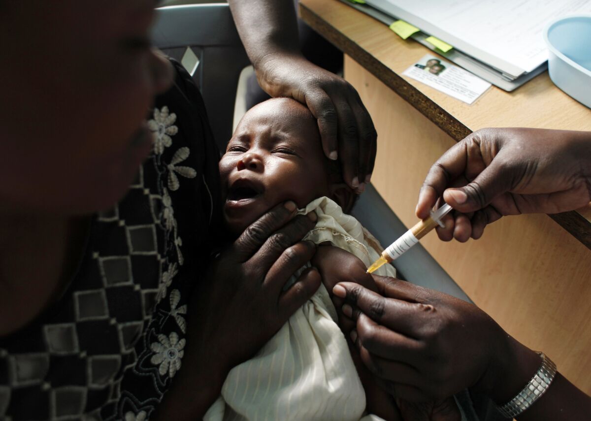 FILE - In this Oct. 30, 2009 file photo, a mother holds her baby receiving a new malaria vaccine as part of a trial at the Walter Reed Project Research Center in Kombewa in Western Kenya. The world’s first malaria vaccine should be given to children across Africa, the World Health Organization recommended Wednesday Oct. 6, 2021, a move that officials hope will spur stalled efforts to curb the spread of the parasitic disease. (AP Photo/Karel Prinsloo, File)