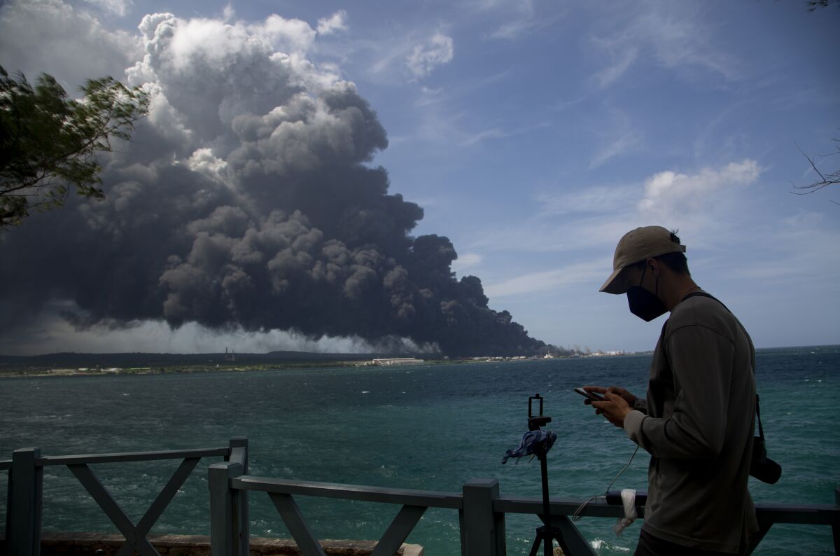 Los trabajadores del Sindicato Petrolero de Cuba observan una enorme columna de humo que se eleva \