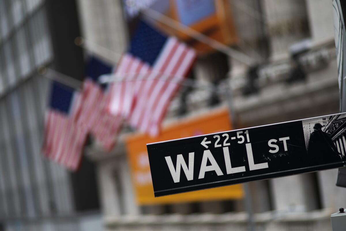 A Wall Street sign in front of the New York Stock Exchange.