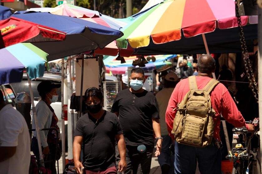 LOS ANGELES, CA - JULY 19, 2020 - - People, wearing masks against the coronavirus, shop along Alvarado Street in MacArthur Park in Los Angeles on July 19, 2020. (Genaro Molina / Los Angeles Times)