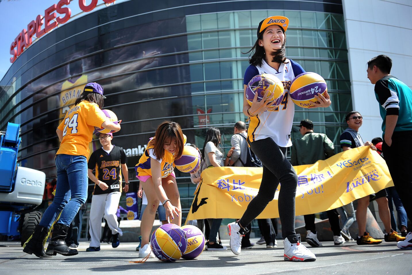 Members of a group of Kobe Bryant fans who flew in from China, including Iris Hong of Beijing, right, get excited outside Staples Center for the player's last game Wednesday.