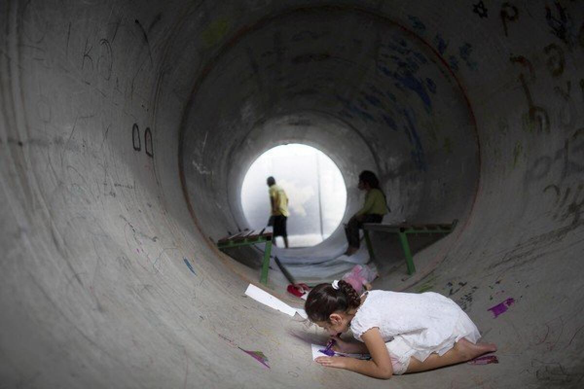An Israeli child in Nitzan draws inside a concrete pipe used as a bomb shelter during the recent conflict with Hamas. Shelter life was one of the topics that provided fodder for Israeli -- and Palestinian -- humor during the strife.
