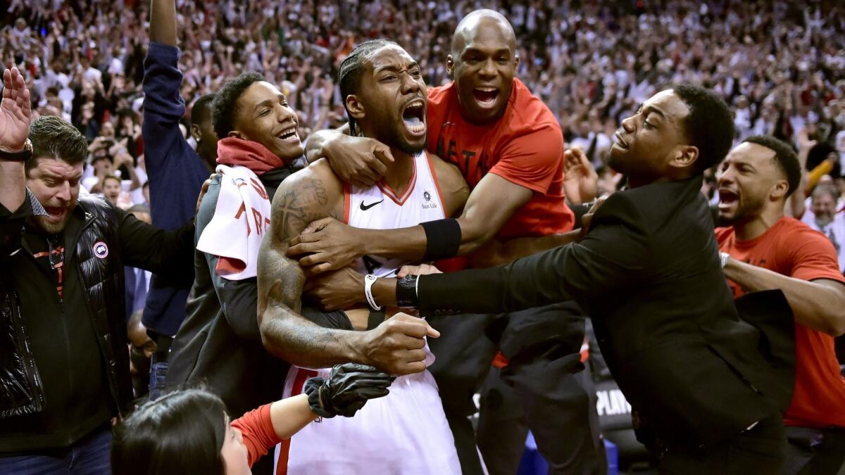 Raptors forward Kawhi Leonard, center in game jersey, celebrates his game-winning basket against the Philadelphia 76ers, on May 12 in Toronto.