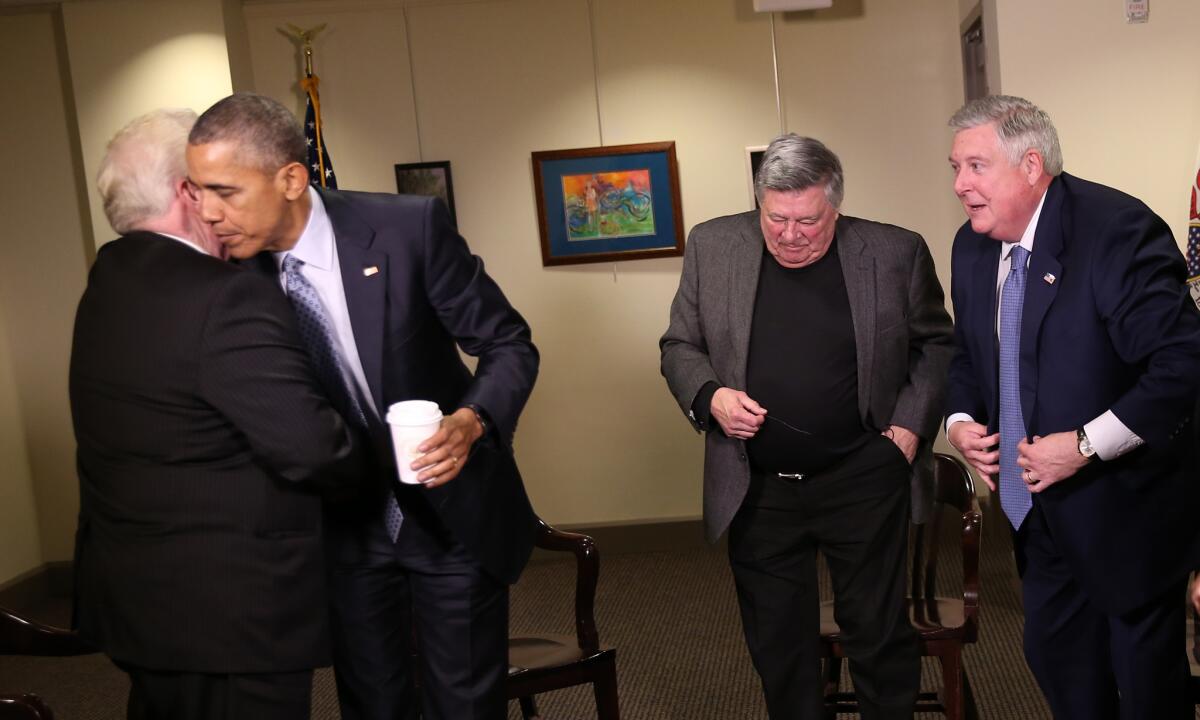 President Barack Obama gives goodbye hugs to his former General Assembly colleagues former Sen. Larry Walsh, former Sen. Denny Jacobs, third from left, and former Sen. Kirk Dillard on Feb. 10, 2016, in Springfield.