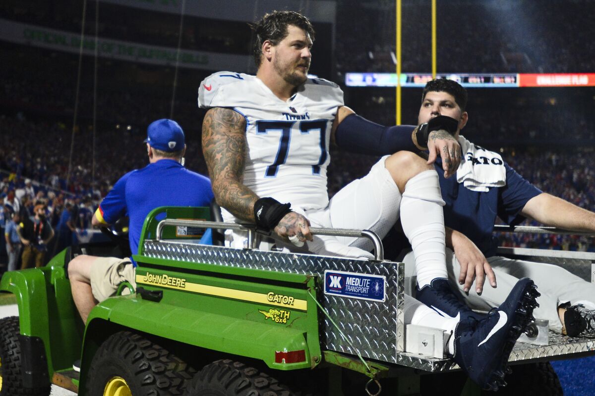 Tennessee Titans offensive tackle Taylor Lewan (77) is carted off the field during the first half of an NFL football game against the Buffalo Bills, Monday, Sept. 19, 2022, in Orchard Park, N.Y. (AP Photo/Adrian Kraus)