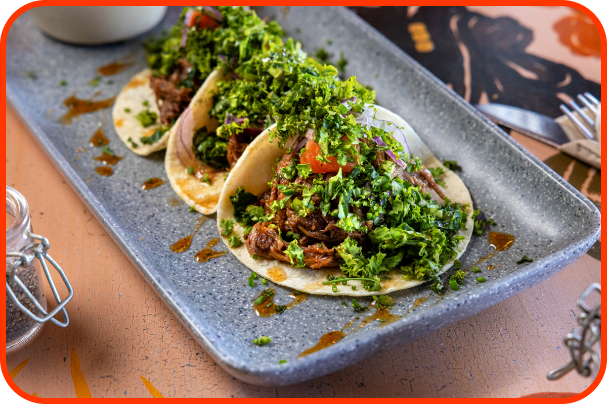 Oxtail tacos with roasted tomato, shreded kale and whiskey reduction.