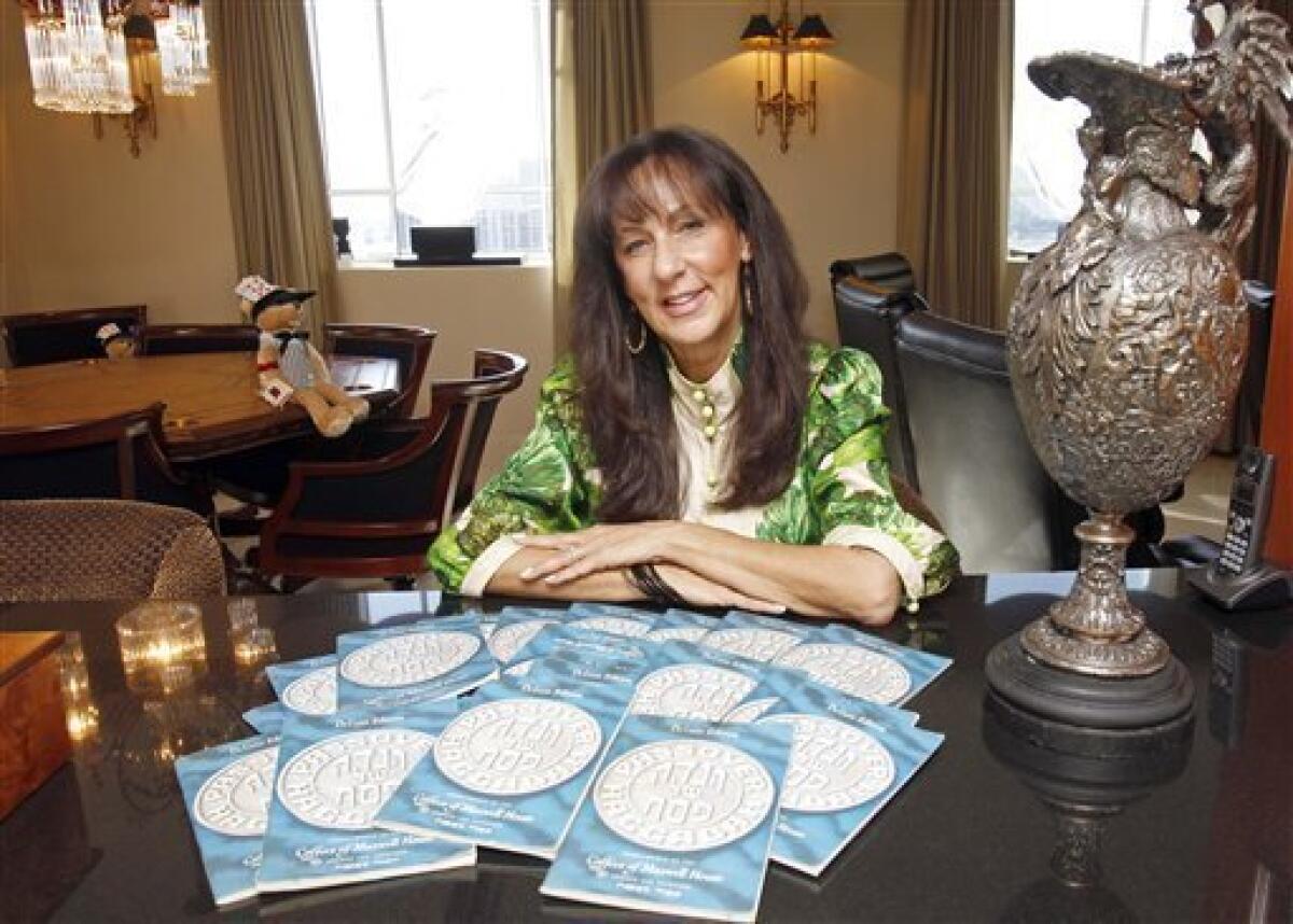 This March 11, 2011 photo shows Susan Schein at her home in Sunny Isles Beach, Fla., with her collection of Maxwell House Haggadahs from 1965 that her father had given her when she started her own family and hosted her first Passover. Susan still uses them today. The coffee maker's version of the Seder guide has been offered free at supermarkets with a Maxwell House purchase since the early 1930s. A major overhaul will be out this year in time for the holiday's start April 18. (AP Photo/Alan Diaz)