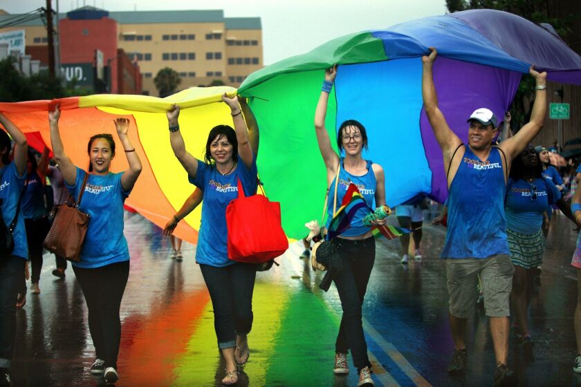 Last year’s rain didn’t stop participants from carrying the rainbow flag down the streets of Hillcrest during the LGBT Pride Parade.