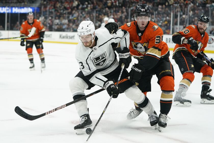 Los Angeles Kings' Matt Roy, left, moves the puck under pressure from Anaheim Ducks' Jamie Drysdale during the first period of an NHL hockey game Friday, Feb. 25, 2022, in Anaheim , Calif. (AP Photo/Jae C. Hong)