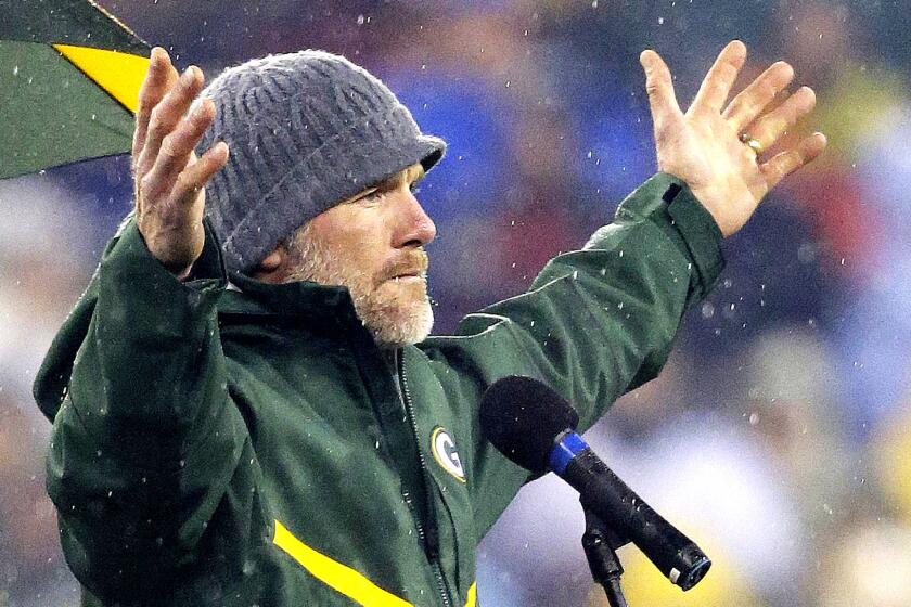 Brett Favre acknowledges the crowd during a ceremony to unveil his retired No. 4 jersey at halftime of the Packers-Bears game on Thursday night.