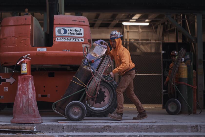 File - Construction workers move equipment on Jan. 17, 2023, in New York. On Tuesday, the Labor Department reports on job openings and labor turnover for August. (AP Photo/Andres Kudacki, File)