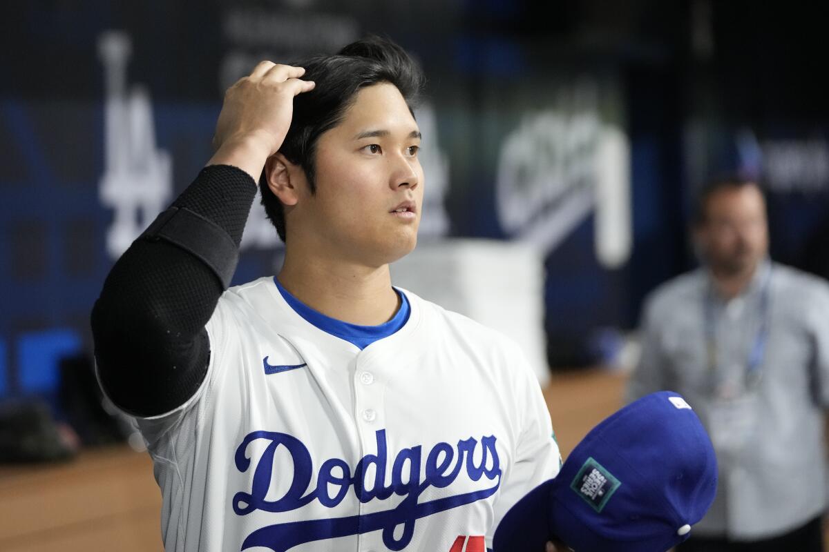 Dodgers designated hitter Shohei Ohtani stands in the dugout before a game.
