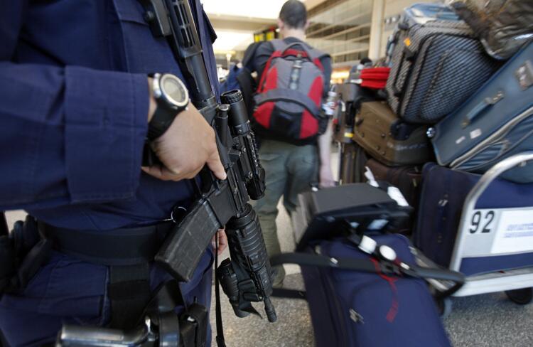 A police officer wields an assault rifle while standing guard at Los Angeles International Airport, where security has been raised since last month's attempted bombing of a commercial jet flying into Detroit.
