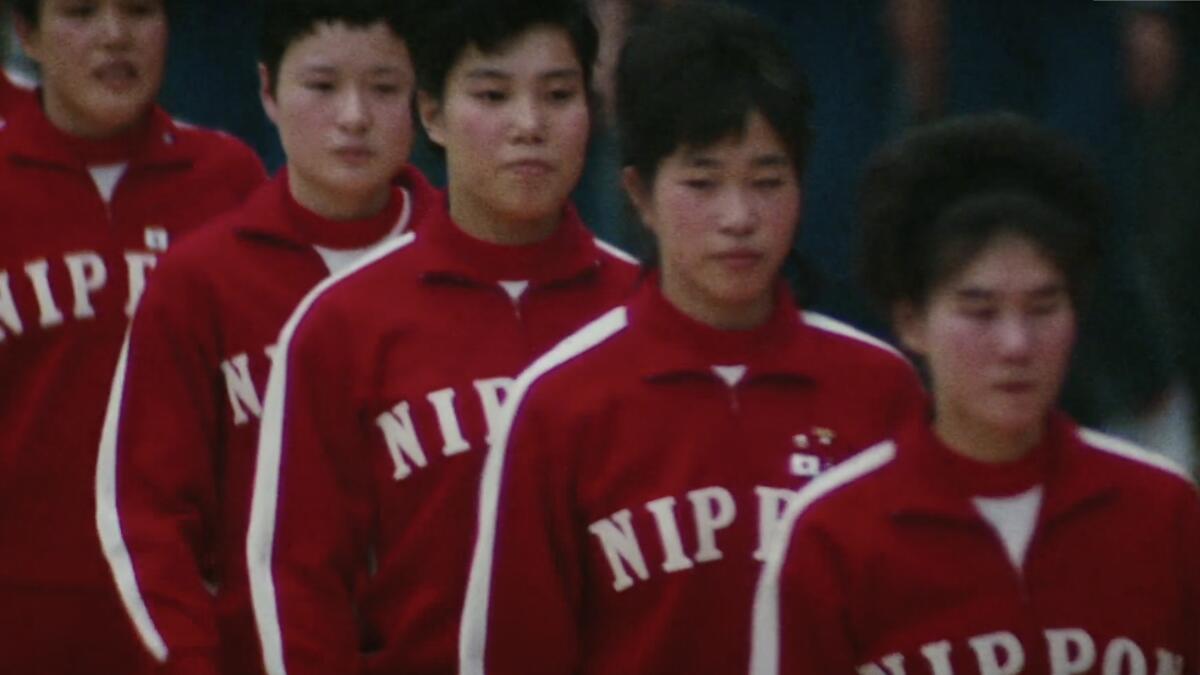 Japanese women wearing red tracksuits with the word "Nippon" in white lettering.