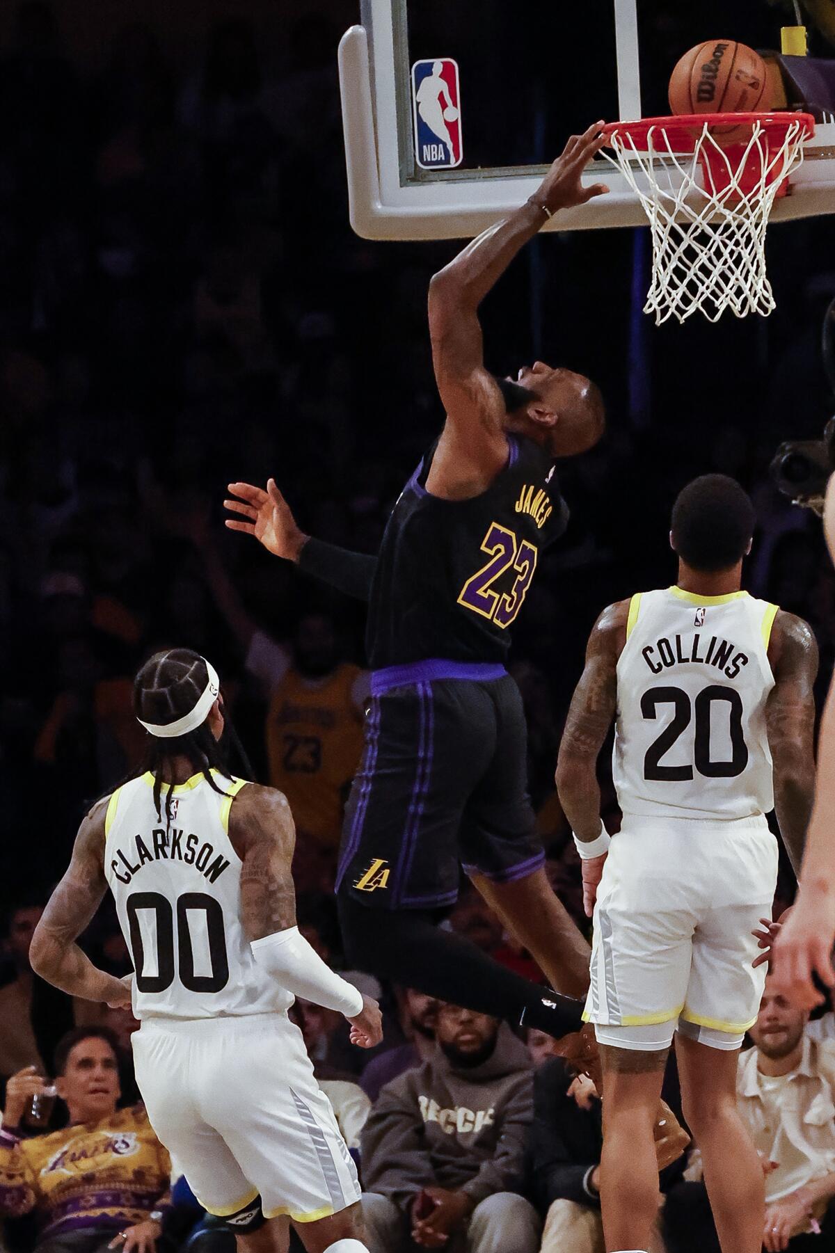 Laker LeBron James, Jazz'den Jordan Clarkson ve John Collins'in önünde bir kovanın içinde yatıyor