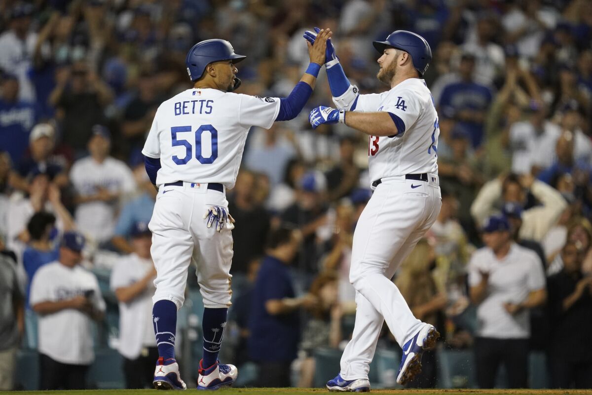 Max Muncy, right, celebrates with Mookie Betts after hitting a two-run home run in the third inning for the Dodgers.