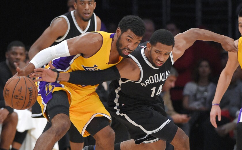 Lakers guard Ronnie Price tries to protect the ball from the reach of Nets guard Darius Morris in the first half.