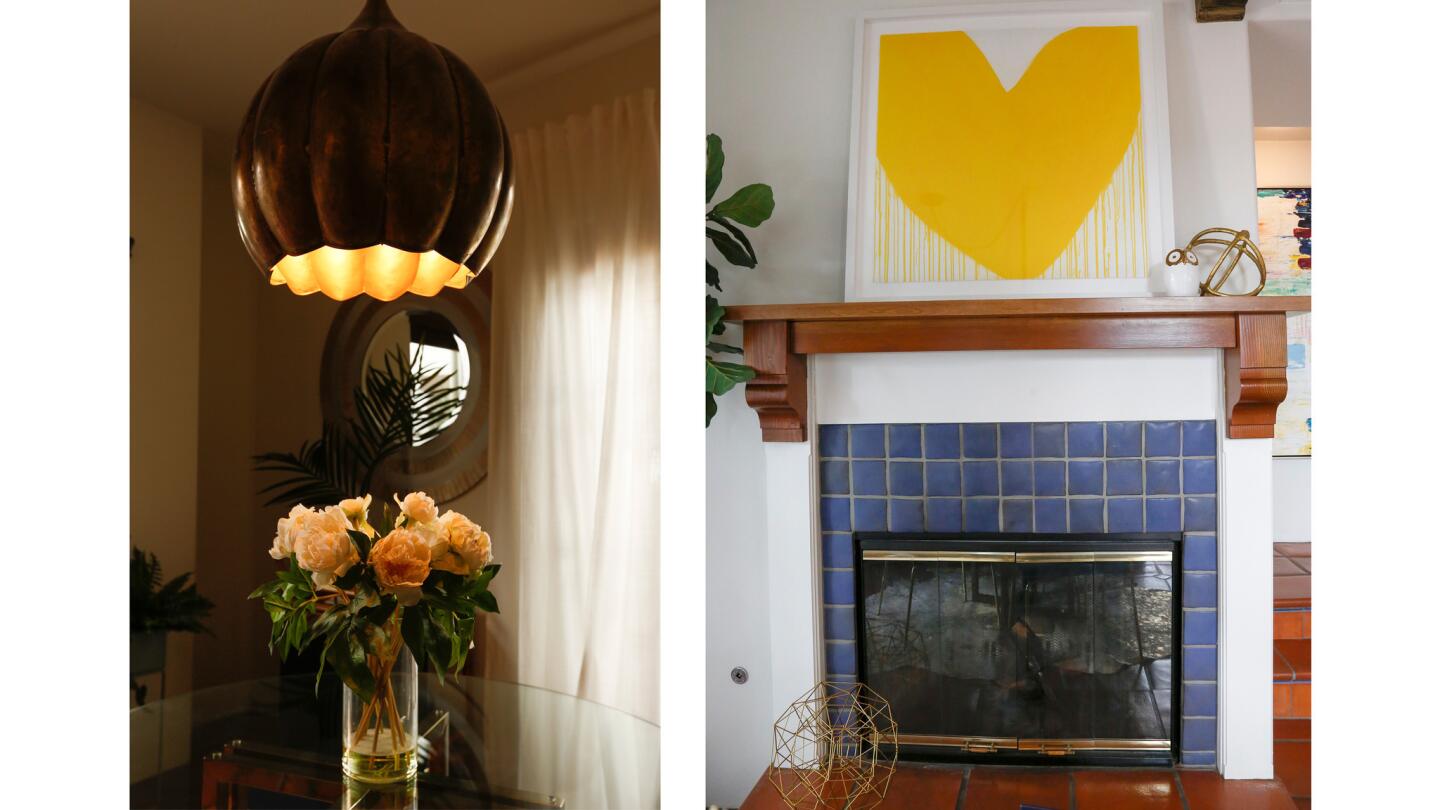 A gold, tulip-shaped pendant light, left, hangs above the glass dining table. A large yellow heart h