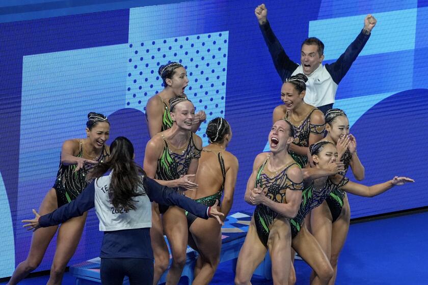 The U.S. reacts after clinching a silver medal in the artistic swimming team acrobatic routine at the Summer Olympics 