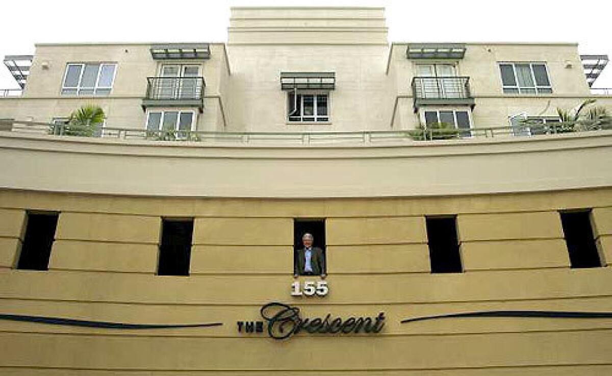 Architect Johannes Van Tilburg looks out of a portal at The Crescent apartments which he designed in Beverly Hills.
