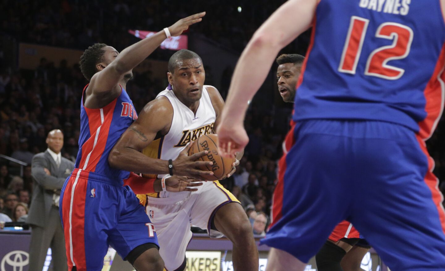 Lakers forward Metta World Peace drives to the basket against three Pistons defenders in the first half.