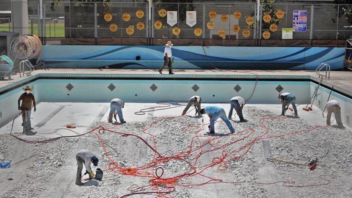 Workers break up the floor of the pool at La Ca?ada High School in 2014.