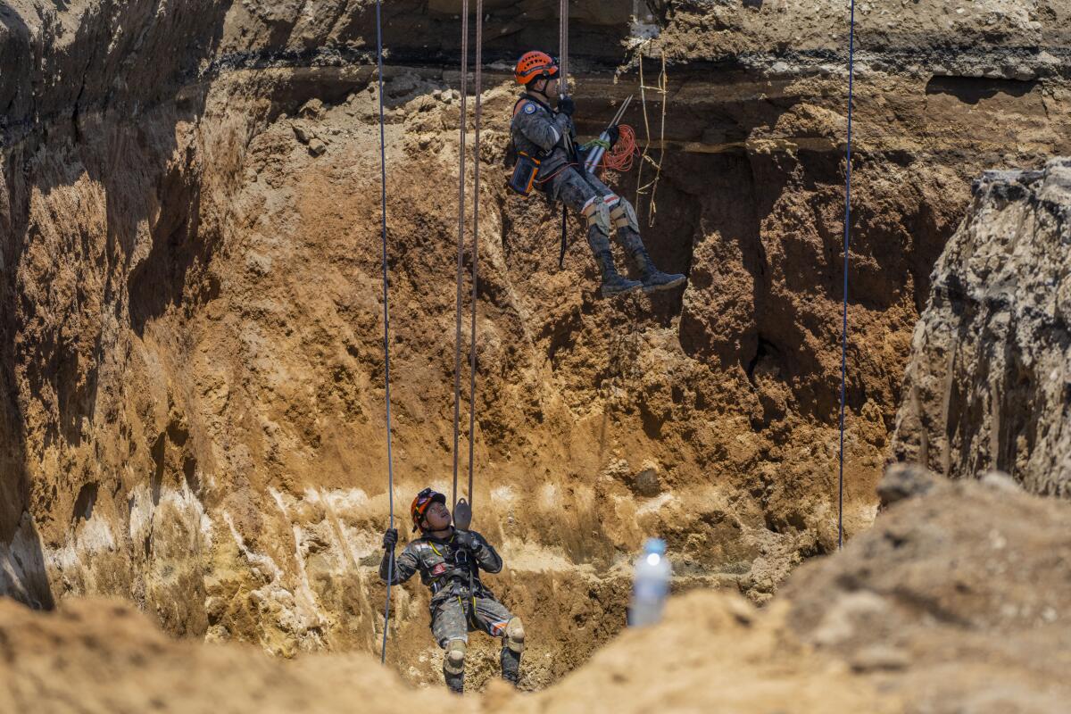 Rescatistas del Ejército de Guatemala descienden a un sumidero en Villa Nueva, Guatemala