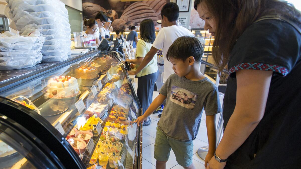 Julian Lai, 8, and his mom, Fiona Kwei, look at the pastries at a bakery at Diamond Jamboree in Irvine last month.
