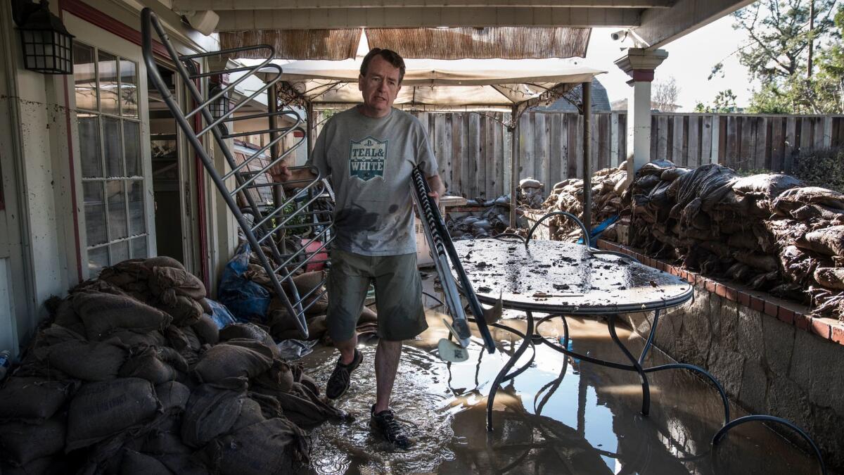 Eric Heckman, who has lived in his house for almost 15 years, clears material from the lower level after the flood.