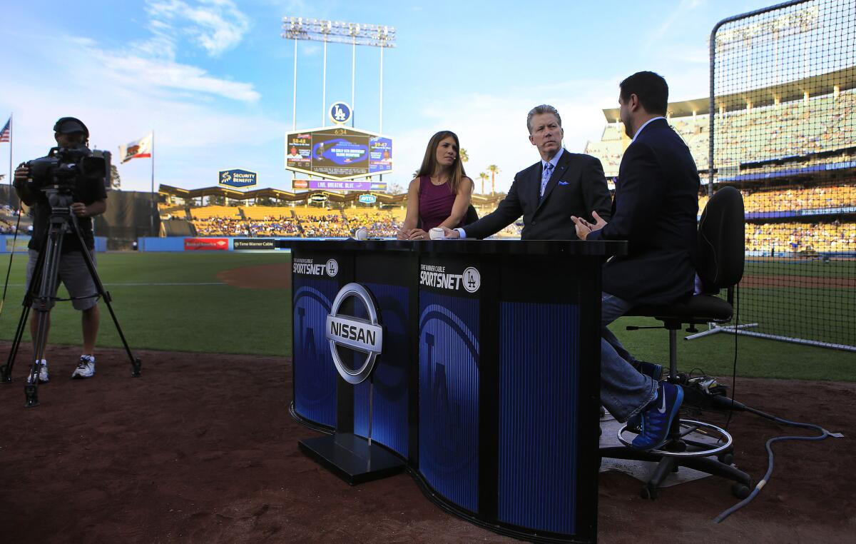 John Hartung anchors a SportsNet LA broadcast with Orel Hershiser and Alanna Rizzo at Dodger Stadium last season.