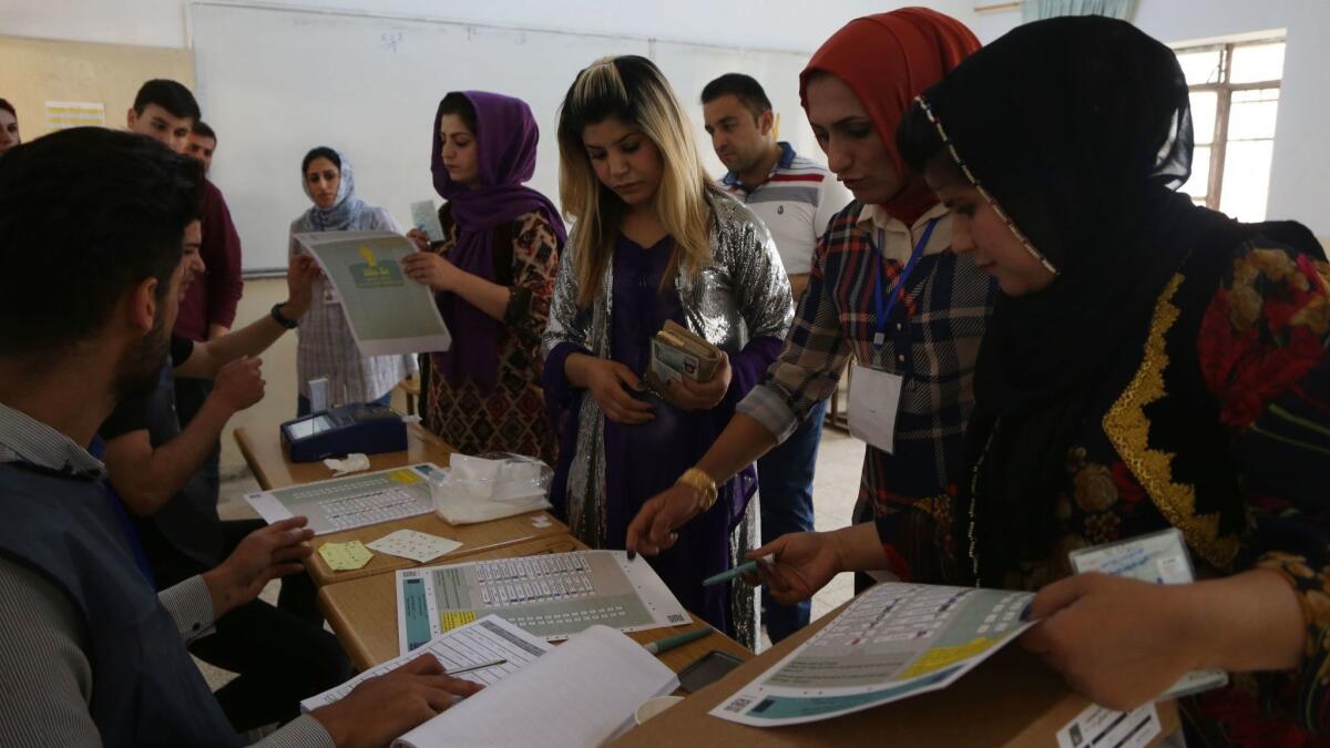 Kurdish Iraqis prepare to vote at a polling station in Irbil during Iraq's parliamentary elections on Saturday.