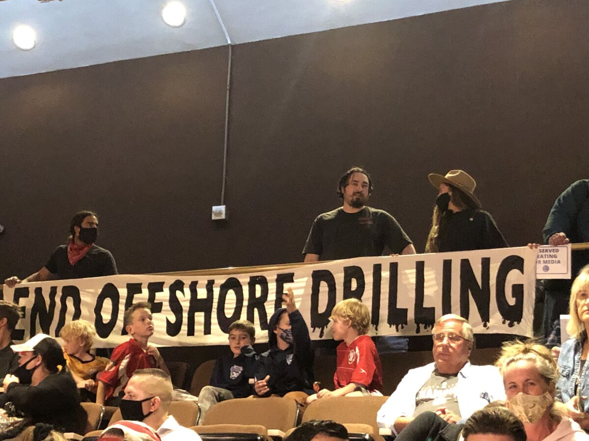 Members of the Surfrider Foundation hold a sign supporting an offshore oil drilling ban