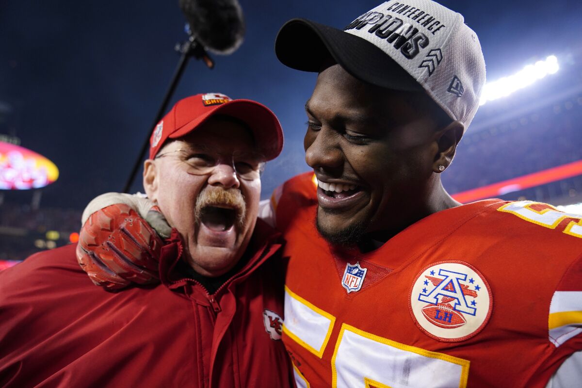 Kansas City Chiefs head coach Andy Reid celebrates defensive end with Frank Clark, right.