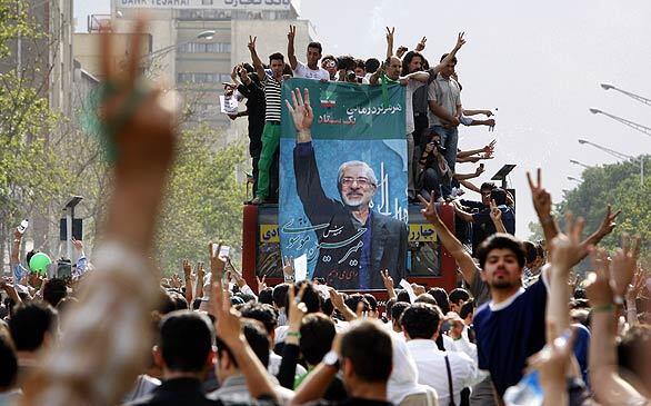 Supporters carry a poster of Iranian presidential candidate Mir Hossein Mousavi during a rally in Tehran. Iran's supreme leader has ordered an investigation of last week's election, a runaway victory for sitting President Mahmoud Ahmadinejad, amid vote-rigging allegations.