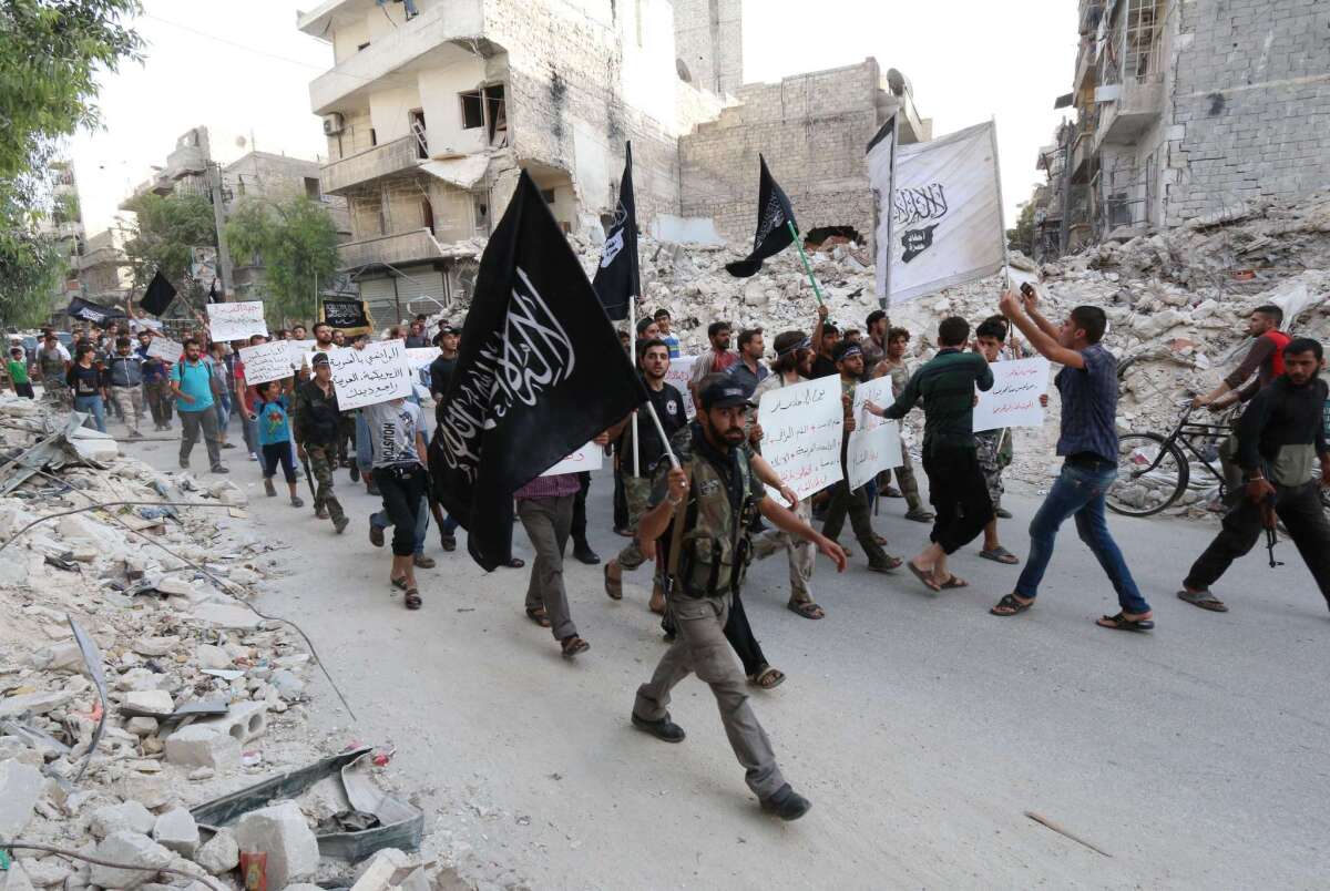 Supporters of the Al Qaeda-affiliated Al Nusra Front demonstrate in Aleppo, Syria, on Sept. 24, carrying placards calling the country's president a terrorist and denouncing Arab states that joined in U.S.-led airstrikes against the militant group Islamic State.