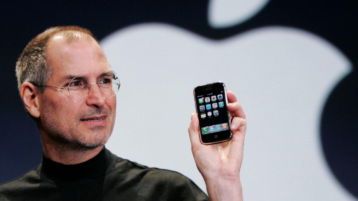 Apple CEO Steve Jobs holds up an iPhone at the MacWorld Conference in San Francisco on Jan. 9, 2007.