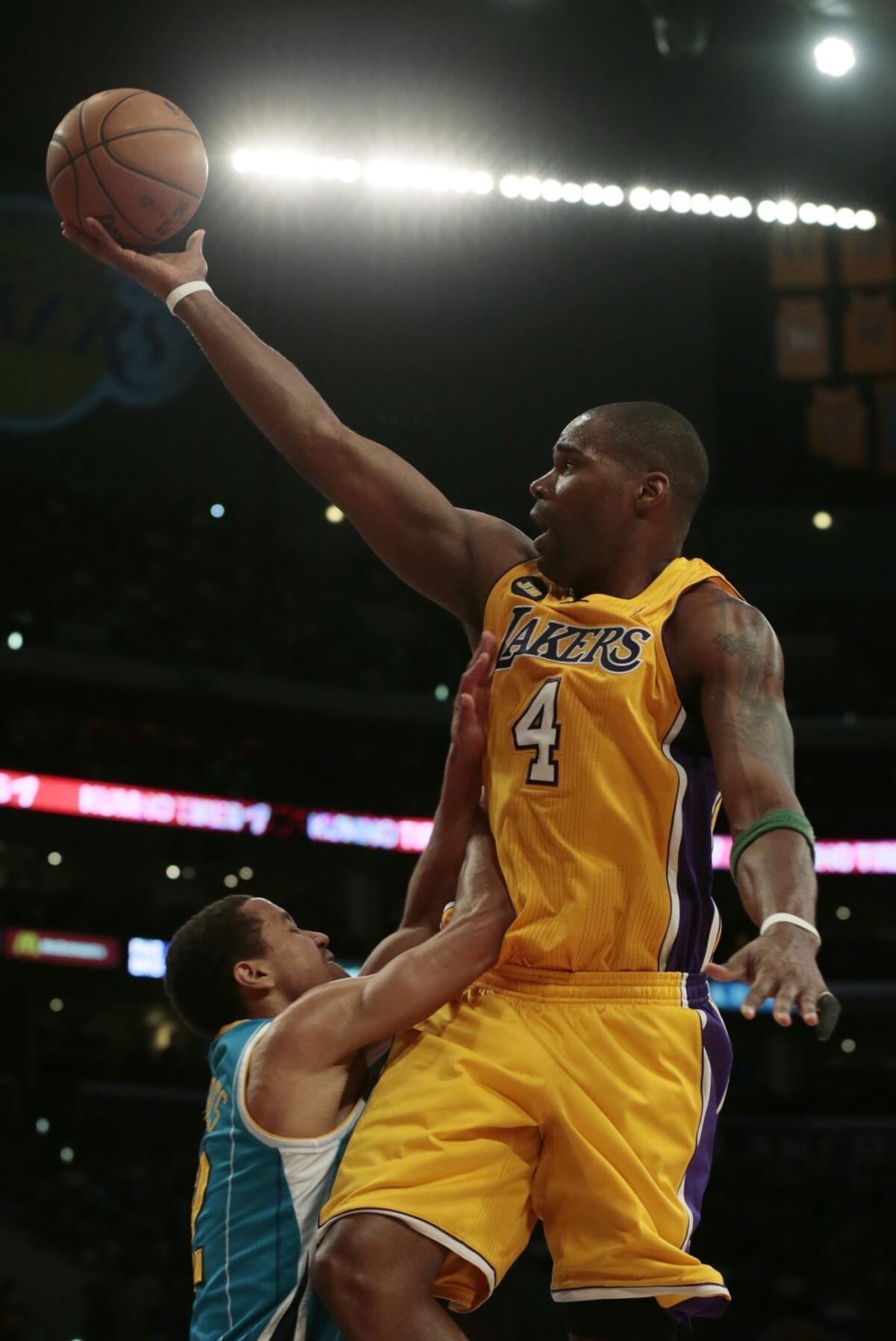 Lakers forward Antawn Jamison is fouled by New Orleans Hornets guard Terrel Harris as he drives to the basket.