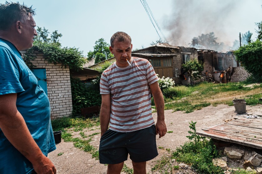 LYSYCHANSK, UKRAINE -- JUNE 11, 2022: Nikolai, last name not given, smokes after trying to salvage his property that caught on fire due to a bombardment that hit his neighborhood in Lysychansk, Ukraine, Saturday June 11, 2022. (Marcus Yam / Los Angeles Times)